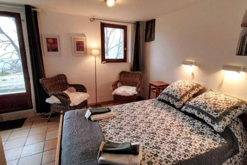 1 dormitorio con 1 cama, 2 sillas y ventana en Chasteuil Locations Studio, en Castellane