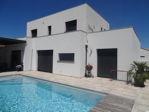 une maison blanche avec une piscine devant dans l'établissement Villa moderne dans quartier calme, à Villeneuve-de-la-Raho