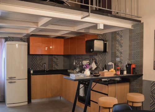 cocina con armarios de madera y nevera blanca en Appartamento a Villa Rosa, en Compiobbi