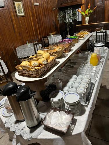 uma mesa longa com pratos e cestos de comida em Hotel Vila Rica em Maringá