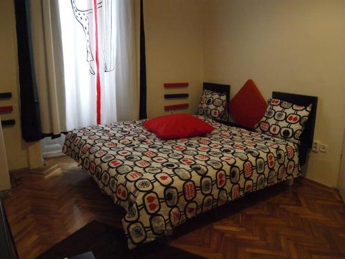 een slaapkamer met een bed met een dekbed en een raam bij Charming Studio at the Danube in Boedapest