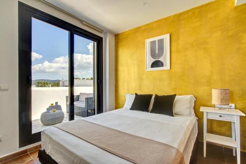 ein Schlafzimmer mit einem großen Bett und einem großen Fenster in der Unterkunft Can Agua IBIZA - Fantastic Villa with pool & BBQ in San Jose de sa Talaia