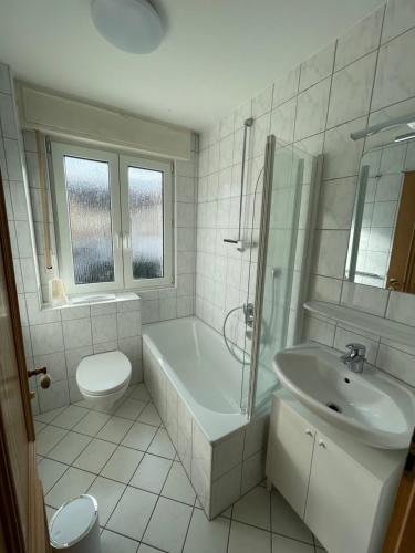 a bathroom with a tub and a sink and a toilet at Ferienwohnung bei Bad Ems im Lahntal in Fachbach