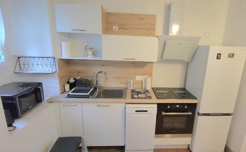 une petite cuisine avec des armoires blanches et un évier dans l'établissement Maison de ville avec Terrasse 