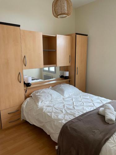ein Schlafzimmer mit einem großen Bett und Holzschränken in der Unterkunft SUPER APPARTEMENT PLAGE BERCK in Berck-sur-Mer