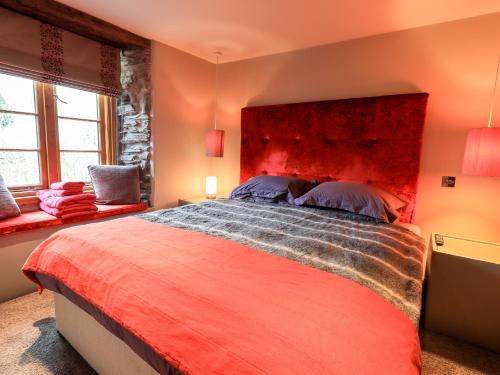 a bedroom with a large bed with a red headboard at The Curious Orange in Windermere