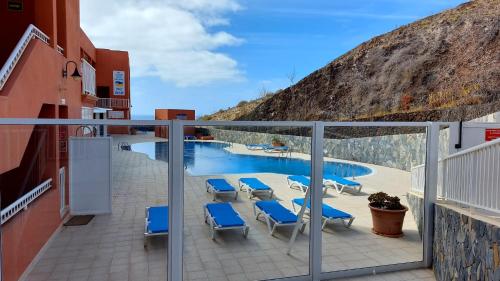 a balcony with blue chairs and a swimming pool at Costa Calma / Playa Paraiso Laguna Blu in Costa Calma