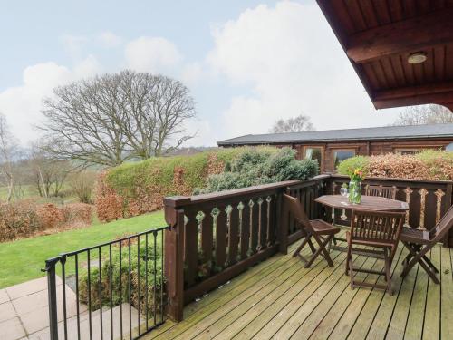 a wooden deck with a table and chairs on it at Valley View in Rhayader