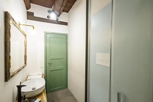Palà Suites في نابولي: حمام له باب أخضر ومغسلة