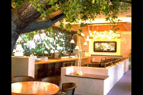 a restaurant with a table and chairs and a tree at Nara Park Hotel in Nara