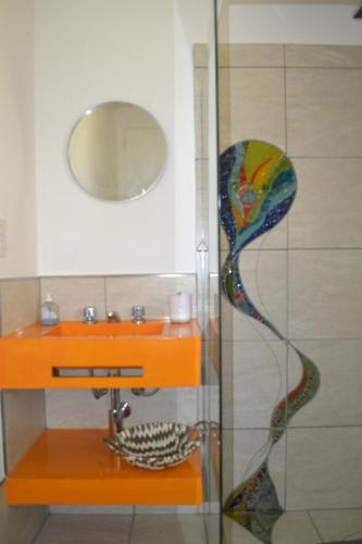 ducha de cristal con lavabo y espejo en Coqueto departamento, Jardines del Rey en Neuquén