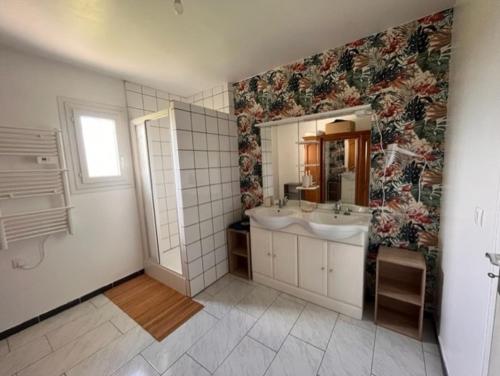 a bathroom with two sinks and a mirror at Les tourterelles 