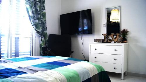a bedroom with a bed and a dresser with a television at MAYA in Paphos City