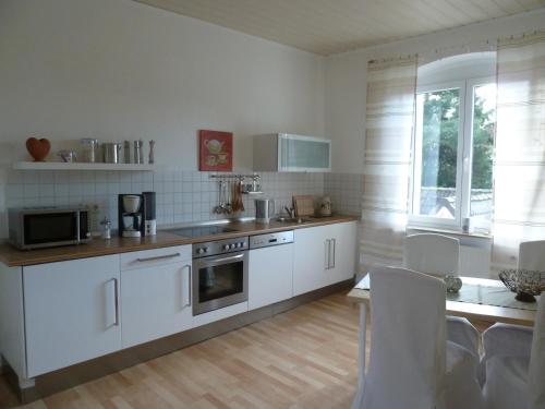 uma cozinha com electrodomésticos brancos e uma mesa com cadeiras em Glück im Kohlenpott em Bottrop