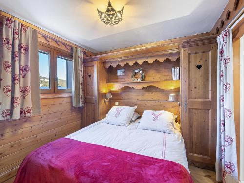 une chambre avec un lit dans une pièce aux murs en bois dans l'établissement Appartement moderne proche pistes avec accès piscine et spa - FR-1-566-53, à Les Allues