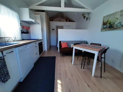 een keuken met een tafel en een woonkamer bij La maisonnette de Suzette in Lanton