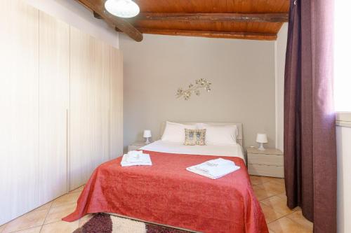 een slaapkamer met een bed met een rode deken bij A casa di Maria in Catania