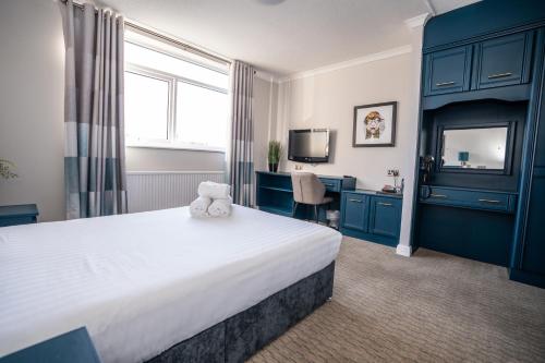 een hotelkamer met een bed met een teddybeer erop bij Birch Hotel in Heywood