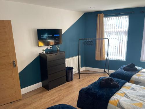 a bedroom with two beds and a flat screen tv at Anfield accomodation in Liverpool