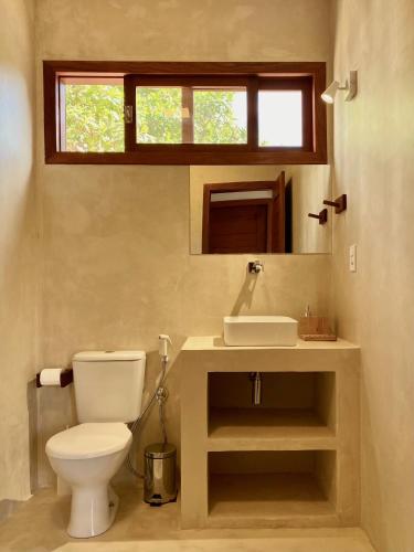 uma casa de banho com um WC, um lavatório e uma janela em Casa Surya em São Miguel do Gostoso