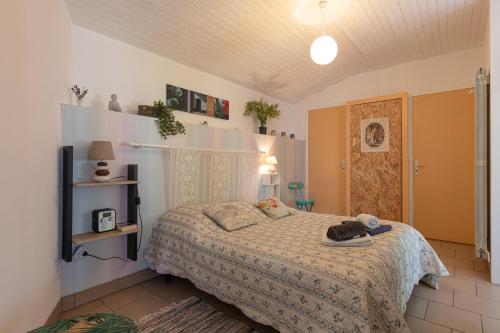 een slaapkamer met een bed in een kamer bij Maisonnette La Chaleureuse in Jonzac
