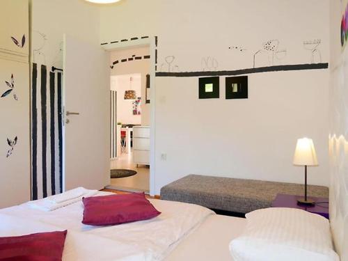sypialnia z łóżkiem z białą pościelą i czerwonymi poduszkami w obiekcie Apartman Maria 2 w Rabie