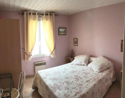 um quarto com uma cama com um edredão branco e uma janela em Maison Des Lys em Jonzac
