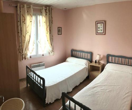 um quarto com 2 camas e uma janela em Maison Des Lys em Jonzac