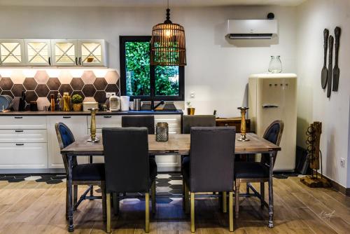 a kitchen with a table and chairs and a refrigerator at Secret de campagne Spa in Grisolles