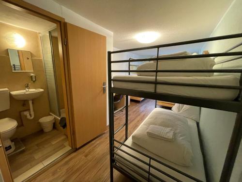 インターラーケンにあるインターラーケン リンダ イン ロッジの二段ベッド2台とバスルームが備わる客室です。
