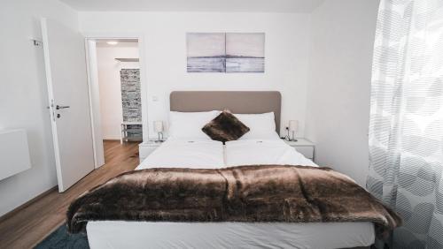 a bedroom with a large bed with a brown blanket at Hotel Guesthouse Dalnig in Bad Kleinkirchheim