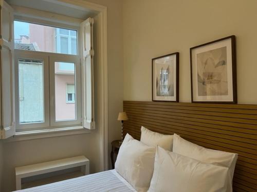 a bedroom with a bed with a wooden headboard and a window at Romantic & Renewed 1 bedroom Apartment in Campolide - 67 1E in Lisbon