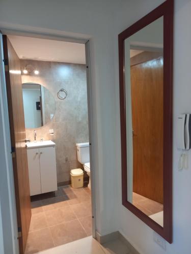 y baño con espejo, lavabo y aseo. en Apart New Green en Salta