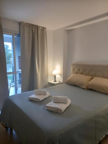 1 dormitorio con 1 cama con 2 toallas en Apart New Green en Salta