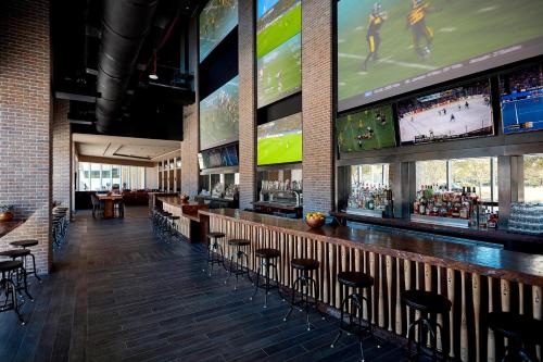 a bar with a bunch of televisions in a ballpark at Marriott Marquis Houston in Houston