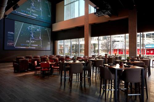 a restaurant with tables and chairs and a large screen at Marriott Marquis Houston in Houston
