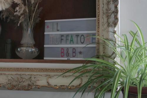 a mirror with a clock and a plant in front of it at Il Tuffatore B&B in Capaccio-Paestum