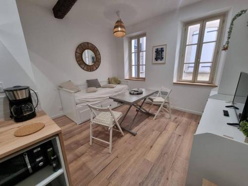 un salon avec une table et un canapé dans l'établissement studio cosy en hypercentre, à Perpignan