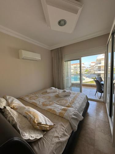 a bedroom with a large bed with a large window at Odyssey Park in Belek