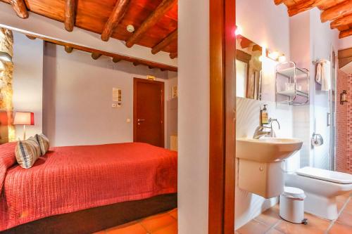 a bathroom with a red bed and a sink at Fonda La Grancha in La Fresneda