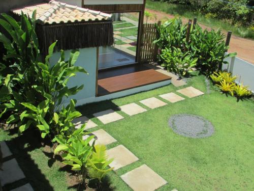 een tuin met een houten terras en gras bij Pousada Refúgio Eça-Porã in Serra Grande