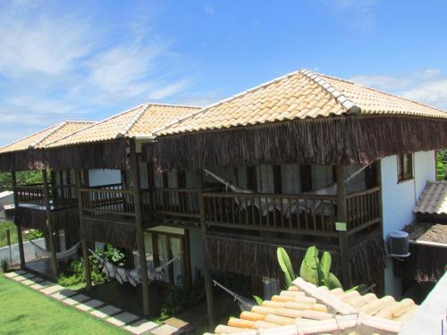 een resortgebouw met een rieten dak bij Pousada Refúgio Eça-Porã in Serra Grande
