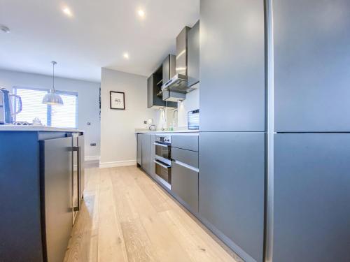 a kitchen with stainless steel appliances and a wooden floor at Geneva House Apartments by Elegance Living in Peterborough