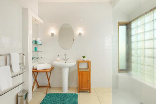 uma casa de banho branca com um lavatório e um espelho em Fendalton Villa - Christchurch Holiday Home em Christchurch