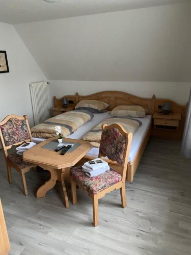 DrolshagenにあるBuddes Wirtshausのベッドルーム1室(ベッド2台、テーブル、椅子付)