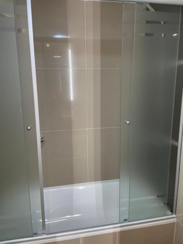 baño con cabina de ducha con puerta de cristal en Amarras Center en Santa Fe