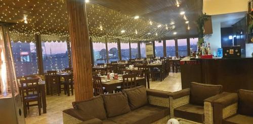 a restaurant with tables and chairs in a room with windows at Saint John Hotel in Madaba