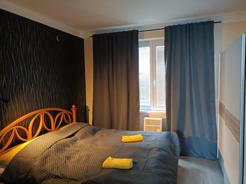 Oldie Apartment Šamorín في شامورين: غرفة نوم عليها سرير ومخدات صفراء