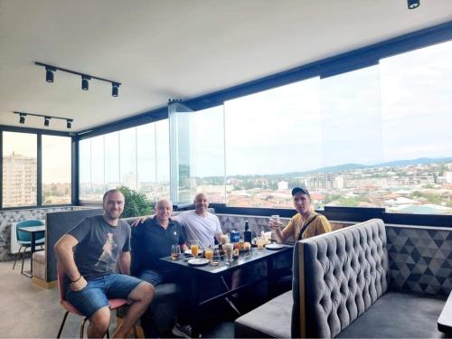 a group of men sitting at a table in a restaurant at Bessarion Boutique Hotel in Kutaisi