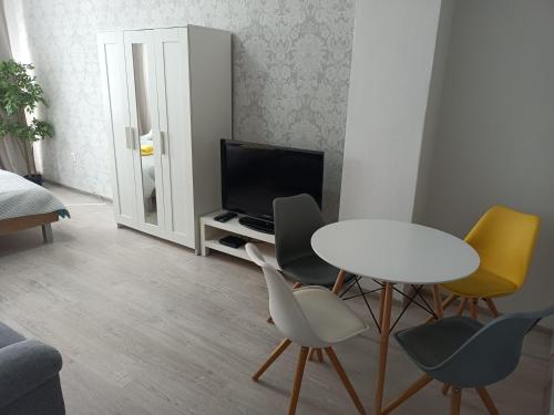 a living room with a table and chairs and a tv at Oldie Apartment Šamorín in Šamorín